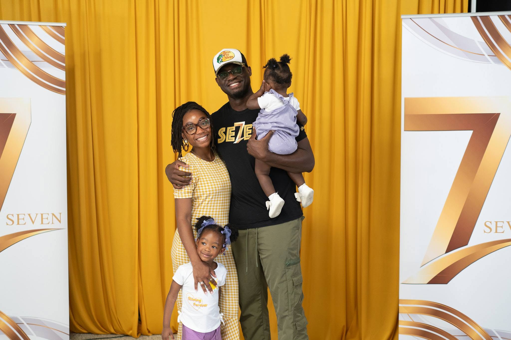 A family of four in front of the Seven backdrop.