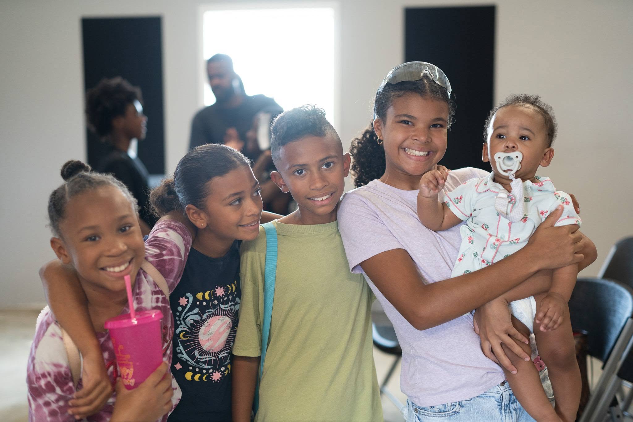 Children from the gathering, smiling together.