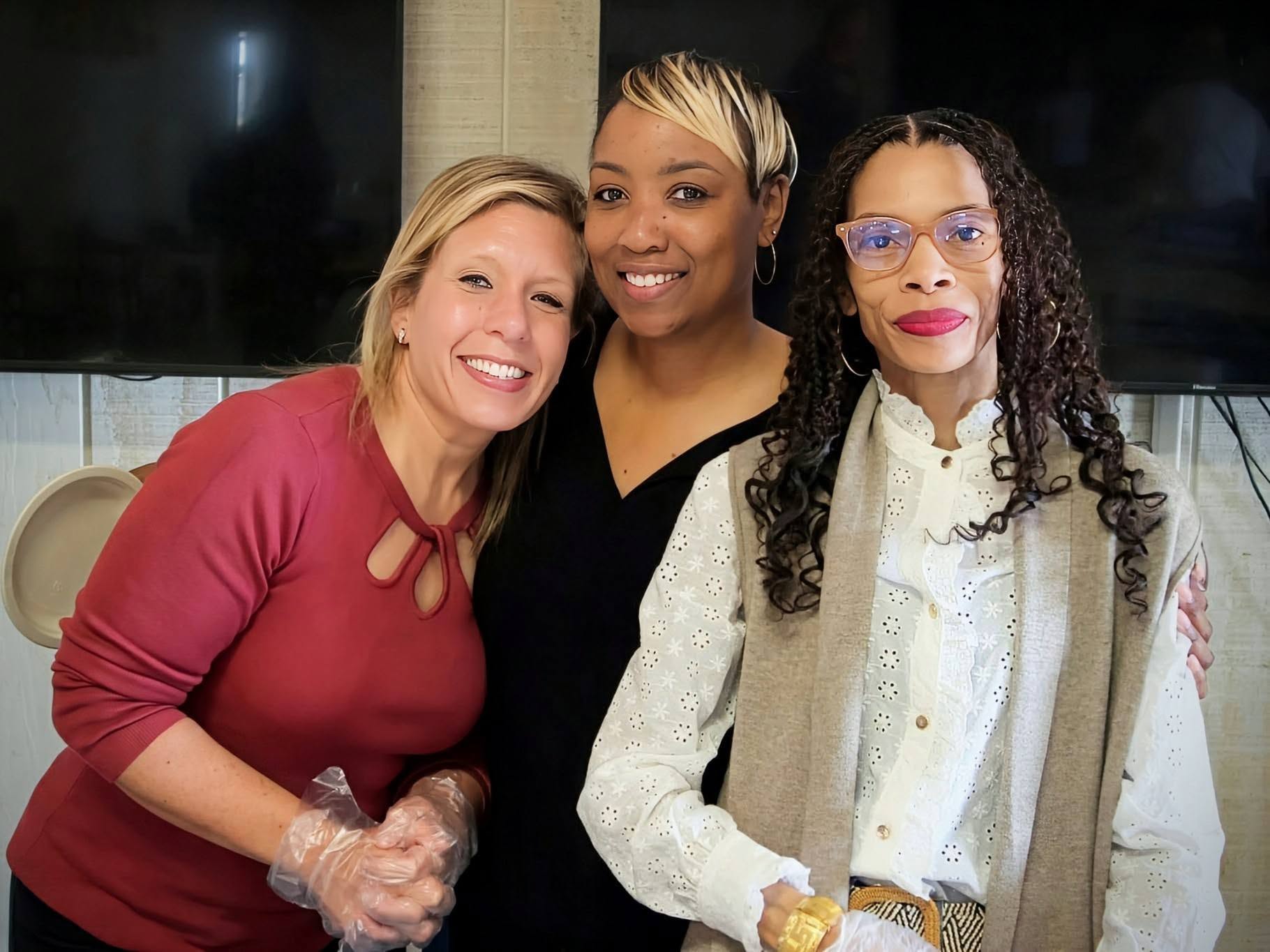 Three women from the gathering, standing together.